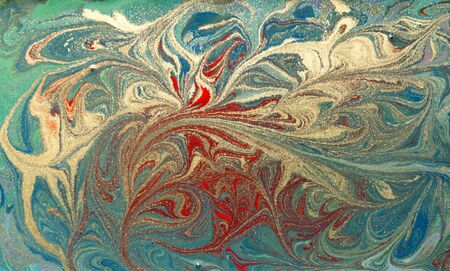 Red and gold liquid texture. Hand drawn marbling background. Ink marble abstract patternの写真素材