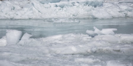 Transparent blue ice hummocks on lake Baikal shore. Siberia winter landscape view. Snow-covered ice...