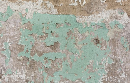 Old painted wall. Green and pink damage surface. Peeling paint background. Stone demaged backdropの写真素材
