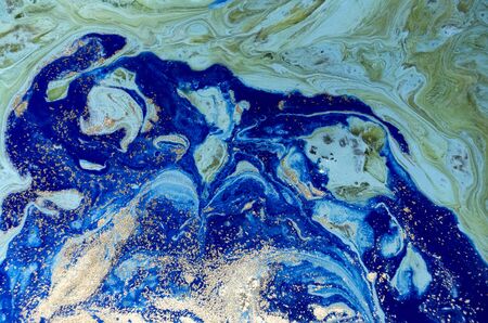 Marbled green and blue abstract background with golden sequins. Liquid marble ink pattern.の写真素材