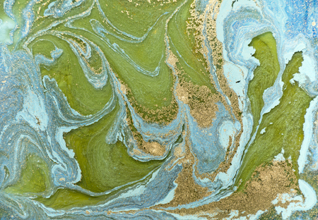 Marbled blue abstract background with golden sequins. Liquid marble ink pattern.の写真素材
