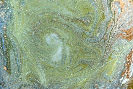 Marbled blue abstract background with golden sequins. Liquid marble ink pattern.の写真素材