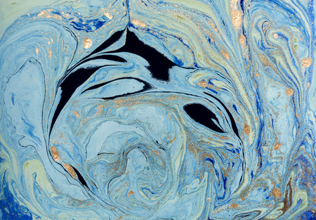 Marbled blue abstract background with golden sequins. Liquid marble ink pattern.の写真素材