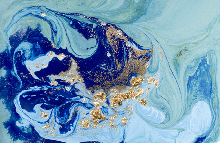 Marbled blue abstract background with golden sequins. Liquid marble ink pattern.の写真素材