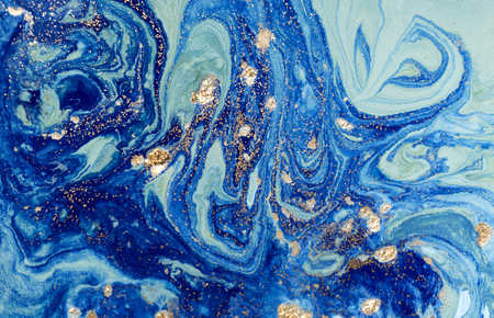 Marbled blue abstract background with golden sequins. Liquid marble ink pattern.の写真素材