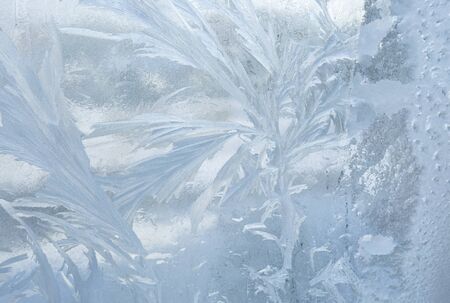 Ice patterns on winter glass. Christmas frozen background. Winter toning effect.の写真素材