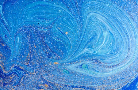 Marbled blue abstract background with golden sequins. Liquid marble ink pattern.の写真素材