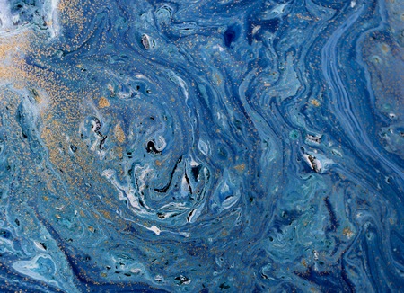 Marbled blue abstract background with golden sequins. Liquid marble ink pattern.の写真素材