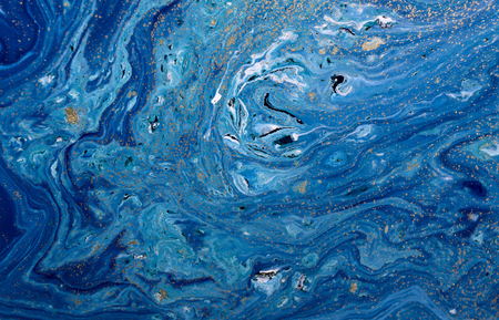 Marbled blue abstract background with golden sequins. Liquid marble ink pattern.の写真素材