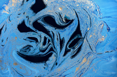 Marbled blue abstract background with golden sequins. Liquid marble ink pattern.の写真素材