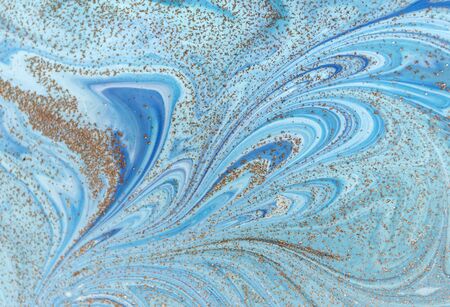 Marbled blue abstract background with golden sequins. Liquid marble ink pattern.の写真素材