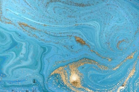 Marbled blue abstract background with golden sequins. Liquid marble ink pattern.の写真素材
