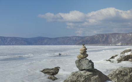 Stone tower on ice blur winter background. Baical landscape.の写真素材
