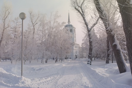 Winter church with trees covered snow. White frost park landscape.の写真素材