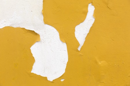 Grunge wall with peeling yellow paint texture.の写真素材