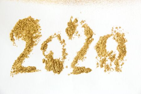 Golden glitter sparkle New Year texture on white background. 2020 lettering.の写真素材