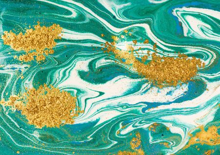 Liquid uneven green marbling pattern with golden glitter and glare of lightの写真素材