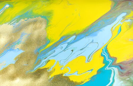 Yellow and blue pastel marble pattern with golden glitter. Abstract liquid background.