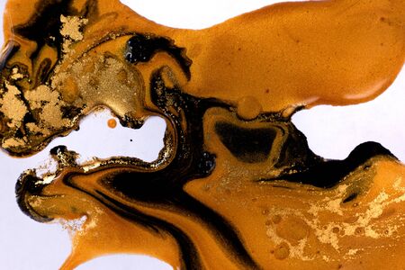 Black and gold mixed inks ripples background.の写真素材