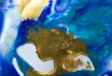 Blue and gold sequins on white paper background.