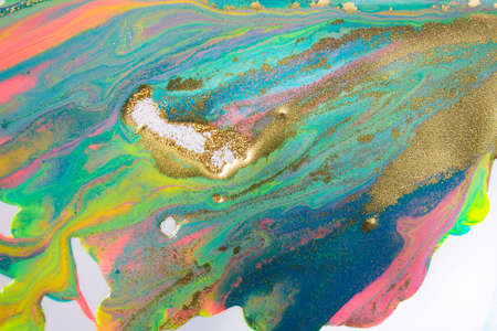 Pink, gold and blue mixed inks splattered on white paper background.