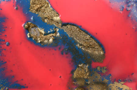 Piles of gold sequins on pink and blue smudges of paint. Abstract pattern.