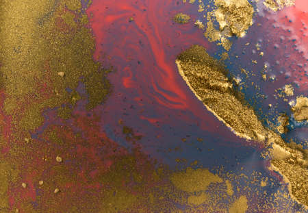 Piles of gold sequins on blue liquid ink background. Abstract pattern.の写真素材