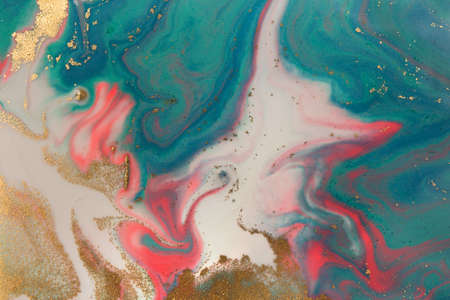 Piles of gold sequins on pink and blue smudges of paint. Abstract pattern.