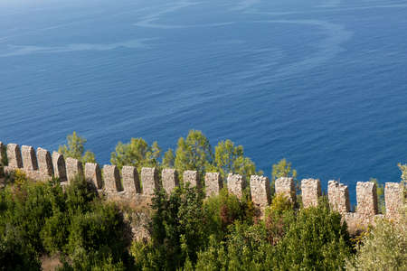 Old fortress stone wall on blue sea background.の写真素材