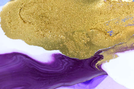 Gold dust on violet liquid acrylic artwork background.の写真素材