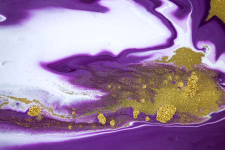 Cose up gold glitter on liquid mixed purple inks backgroundの写真素材