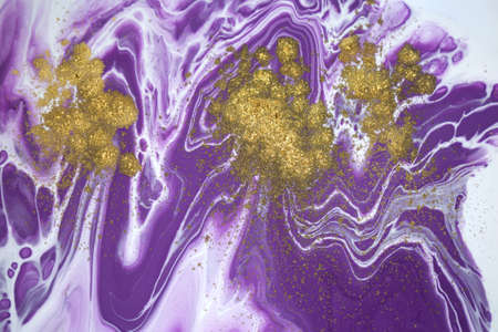 Cose up gold glitter on liquid mixed purple inks background.の写真素材