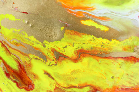 Abstract yellow marble pattern with gold glitter. Liquid paint background.