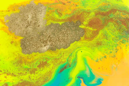 Gold spots on rainbow smudges of paint. Abstract pattern.