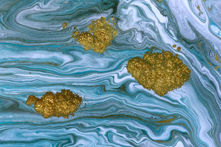 Streams of liquid blue, white and gold ink curls. Waves of fluid turquoise and golden fluid paint.