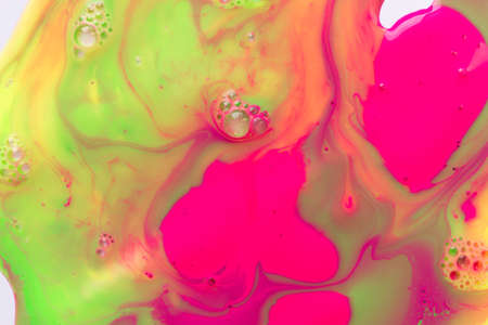 Liquid fluorescent pink and green paints background with bubbles. abstract print.の写真素材
