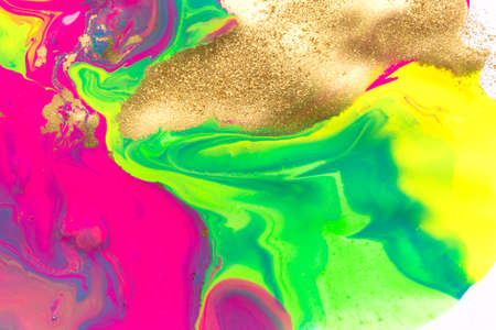 Gold dust spots on liquid fluorescent paints on white background.の写真素材