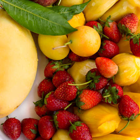 Tropical fruits set background. Mango, plum, strawberryの写真素材