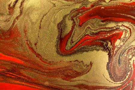 Gold waves on dark red background.の写真素材