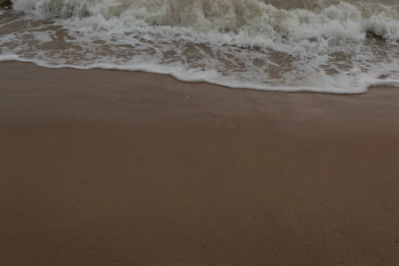Sea Wave Foam on the Sand Beach Close Up Backgroundの写真素材