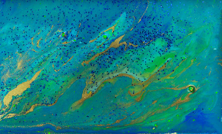 Blue and Gold Glitter on Liquid Blue Ink Background.の写真素材