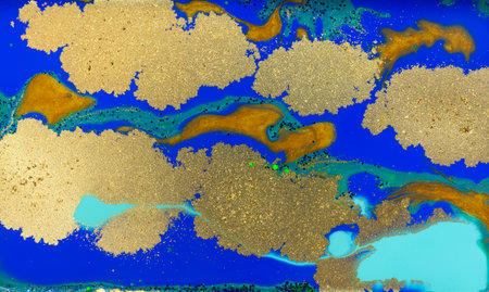 Blue and Golden Dust Placer on Liquid Blue Ink Background.の写真素材
