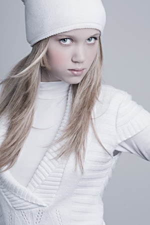 beautiful girl with perfect skin, bright fiber optic with warm white clothes and a hat on a light backgroundの写真素材