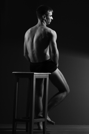 strong man with a perfect muscular body on a black backgroundの写真素材