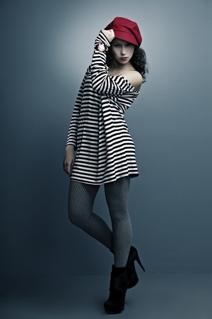portrait of a beautiful girl with bright make-up, the clock in a cap and sailor on a dark backgroundの写真素材