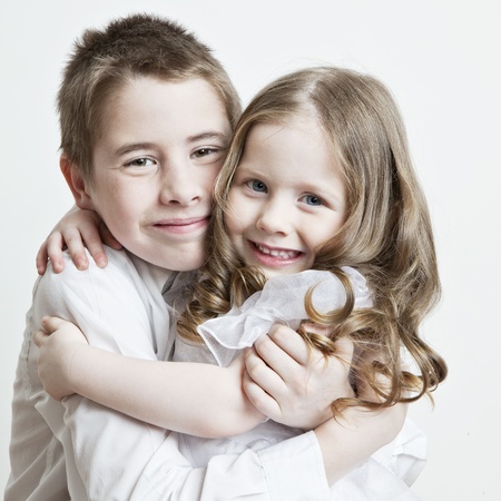 Portrait of a child, the love of brother and sister in his arms on a white backgroundの写真素材