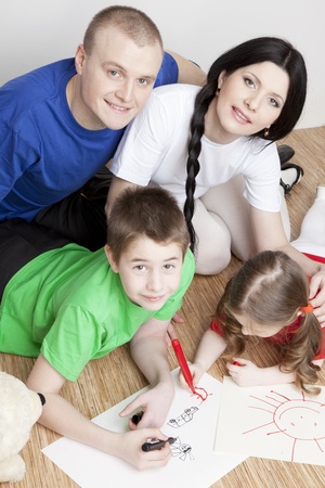 Portrait of a beautiful family  parents and children play together and drawの写真素材