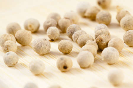 a collection of white pepper corns on woodの写真素材