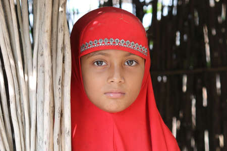 looks - a village girl look through to the camera while photographing . she is a beautiful ed kid with special coloured iris -e is living in a slum for migrated people  at digirpar of munshigonj district , bangladeshのeditorial素材