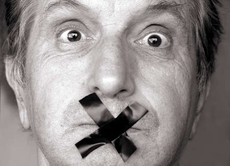 censure!stop talking! man with adhesive tape over his mouth. sepia tone        の写真素材
